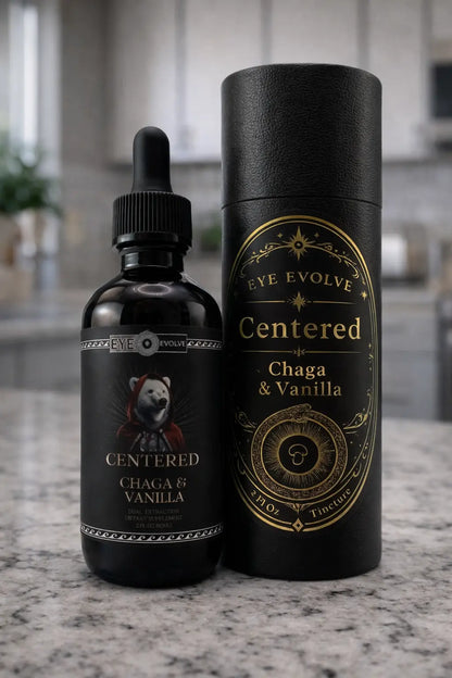 Black bottle and cylindrical container labeled 'Eye Evolve Centered Chaga & Vanilla' on a marble surface.