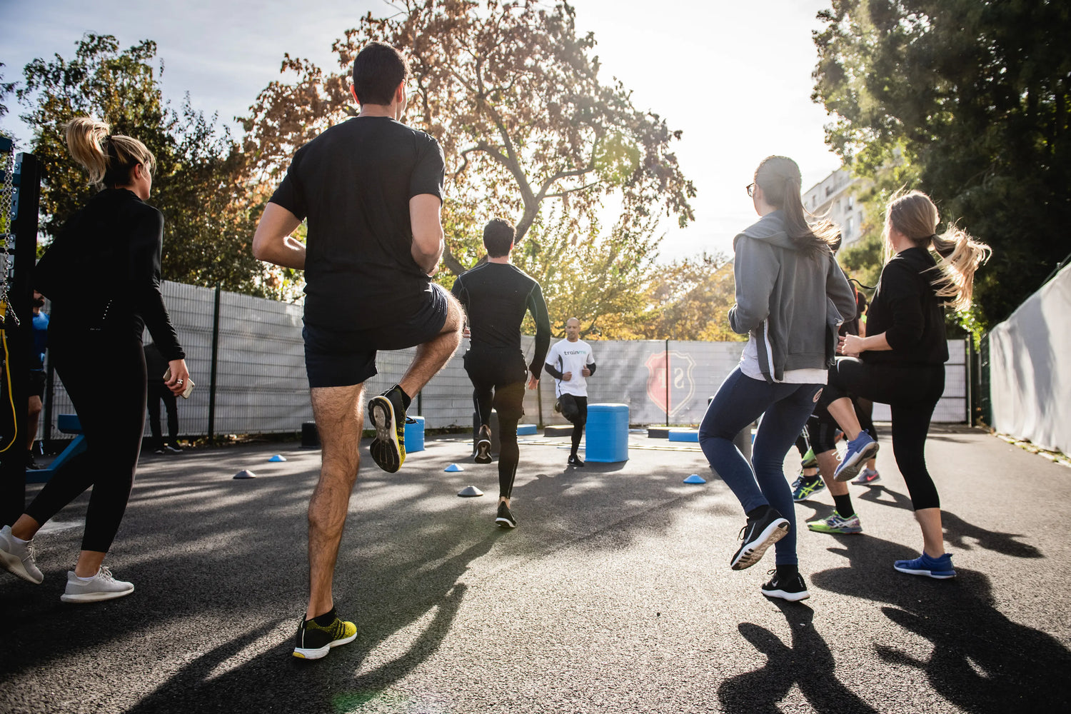 group-of-people-stand-facing-a-fitness-instructor