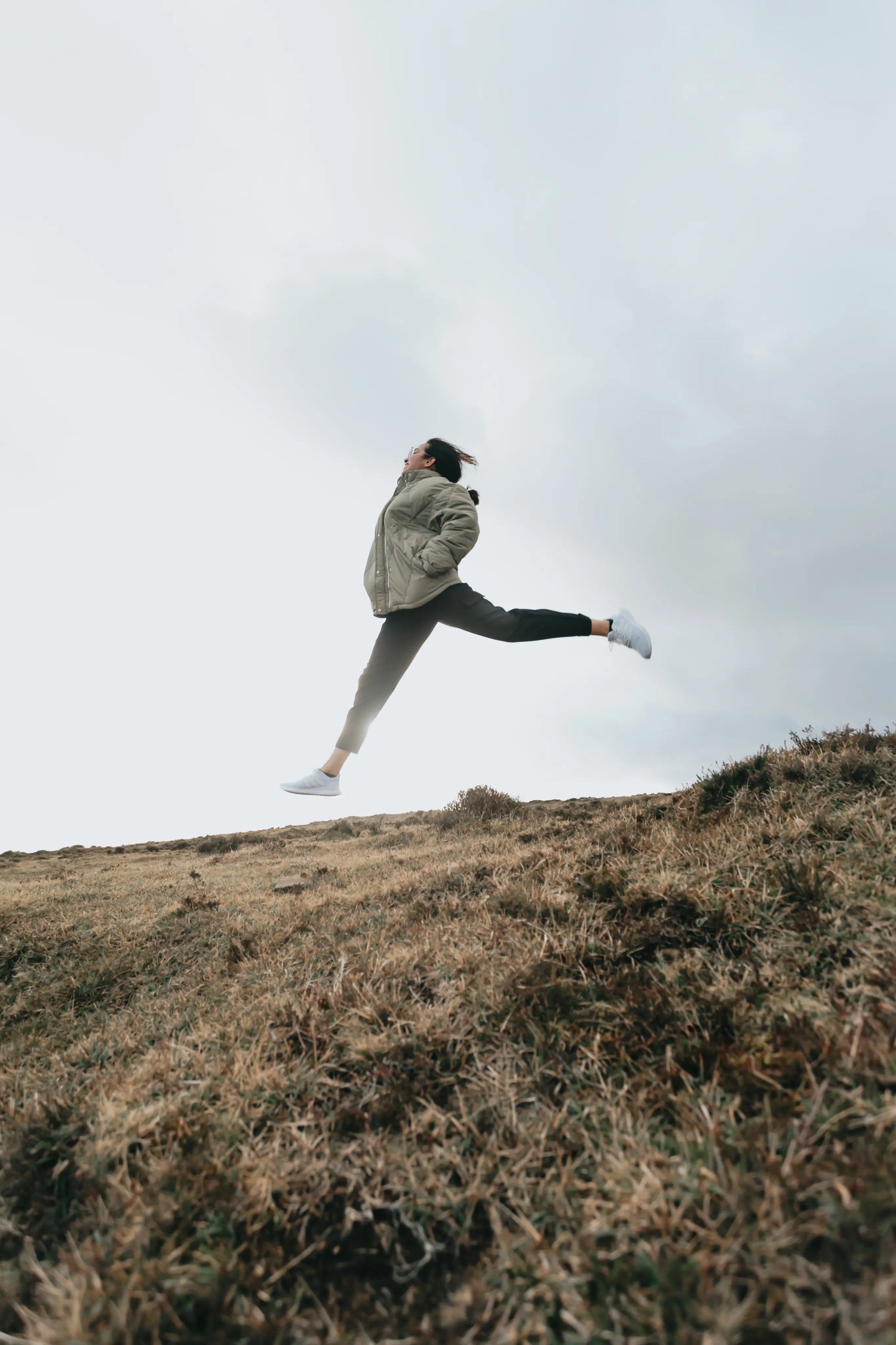 person-jumps-high-with-legs-out-above-